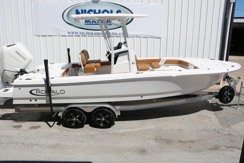 Slide: The Image of 2026 Robalo 246 Cayman boat on trailer, displayed outdoors at dealership. - 12