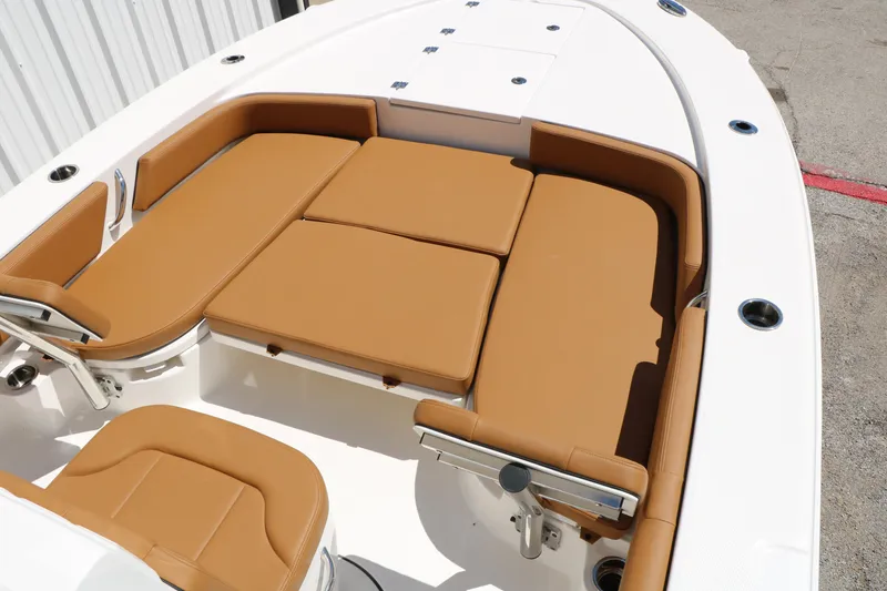 Slide: The Image of 2026 Robalo 246 Cayman boat with tan cushioned seating and sleek white deck design. - 22