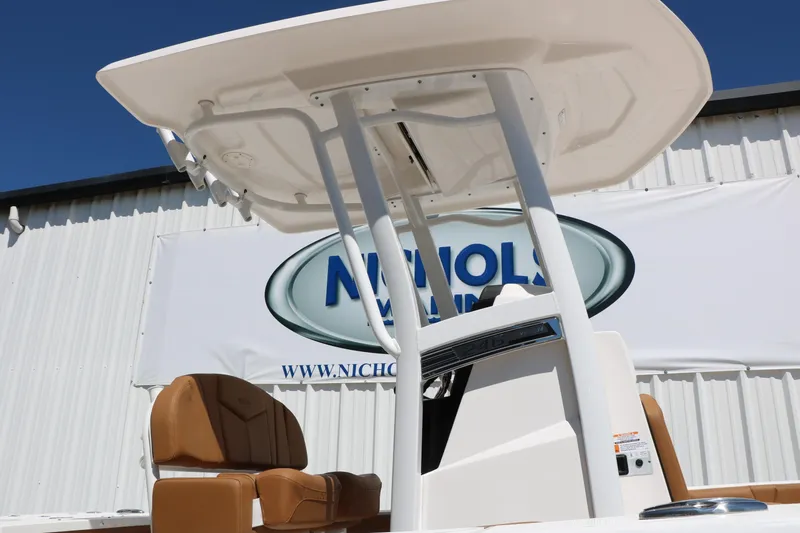 Slide: The Image of 2026 Robalo 246 Cayman boat with T-top and tan seating, displayed outdoors. - 8