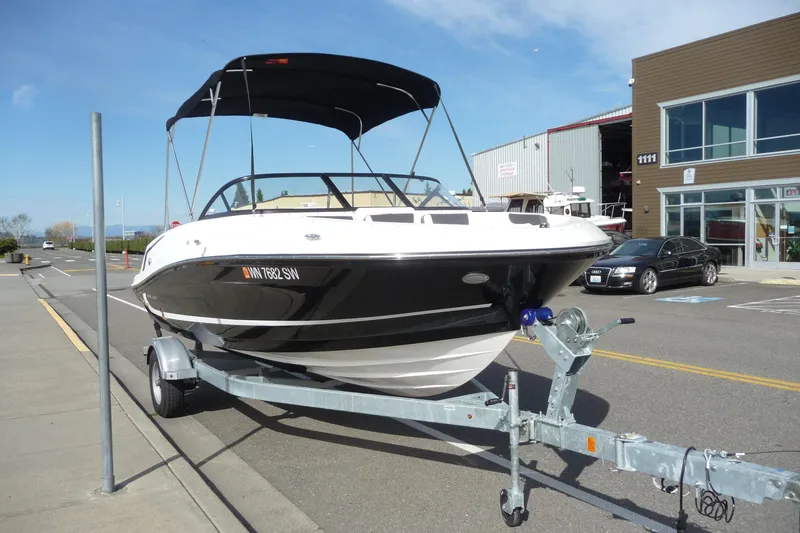 Slide: The Image of 2021 Bayliner VR5 Bowrider I/O on trailer, parked near a modern building. - 12