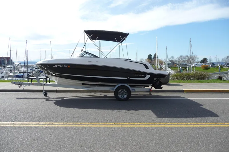 Slide: The Image of 2021 Bayliner VR5 Bowrider I/O on trailer near marina, clear sky background. - 16
