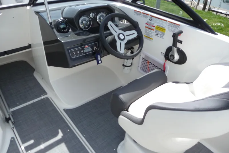 Slide: The Image of 2021 Bayliner VR5 Bowrider I/O cockpit with steering wheel and control panel. - 6