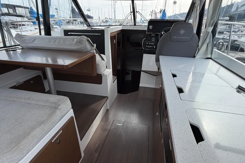 Slide: The Image of Interior of 2022 Jeanneau NC Weekender 1095 Fly, featuring modern seating and navigation area. - 10