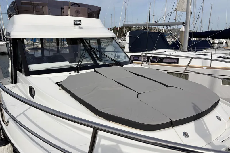 Slide: The Image of 2022 Jeanneau NC Weekender 1095 Fly yacht docked at marina, featuring sunbathing area. - 25