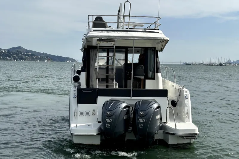 Slide: The Image of 2022 Jeanneau NC Weekender 1095 Fly with dual Yamaha engines on the water. - 4