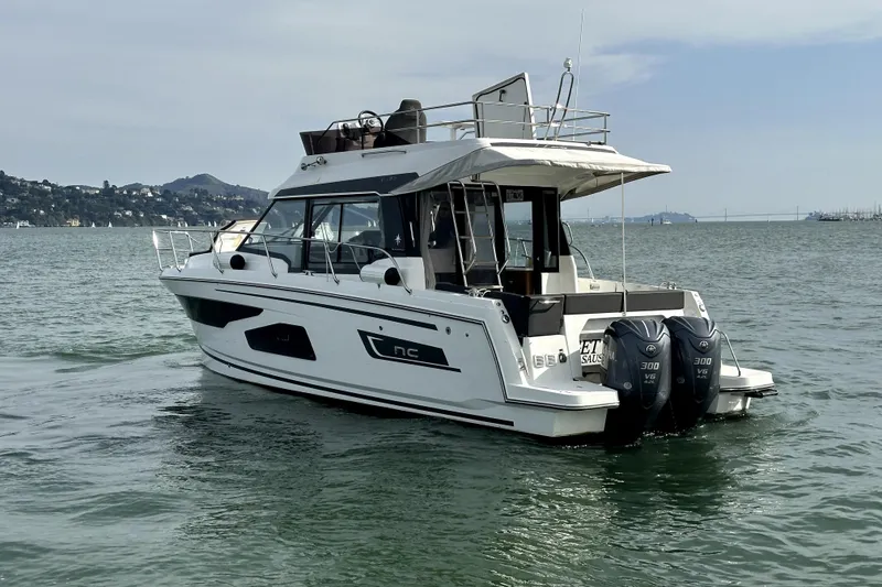 Slide: The Image of 2022 Jeanneau NC Weekender 1095 Fly boat on calm water, featuring twin engines. - 5
