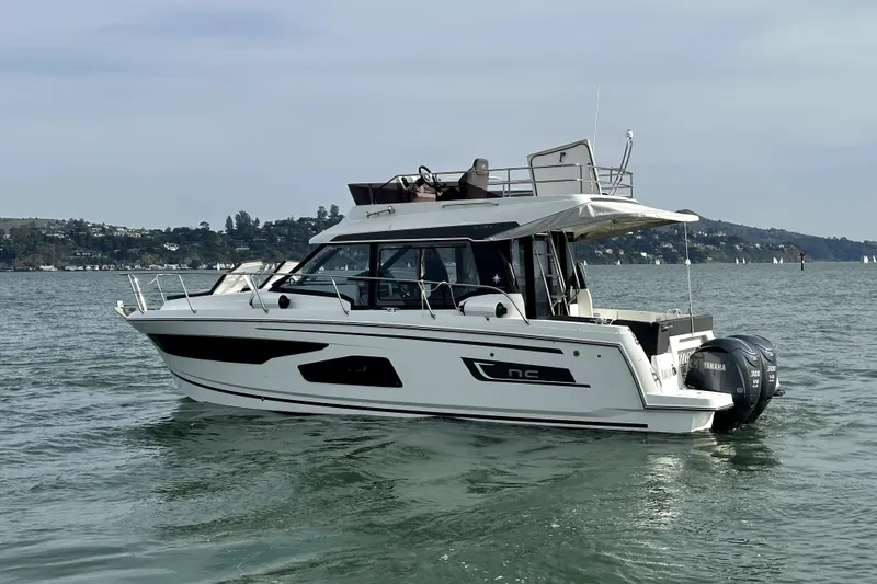 Slide: The Image of 2022 Jeanneau NC Weekender 1095 Fly boat on calm water, side view. - 6