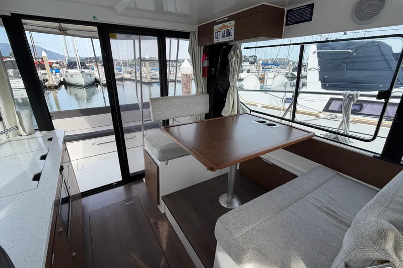Slide: The Image of Interior of 2022 Jeanneau NC Weekender 1095 Fly, featuring dining area and marina view. - 9