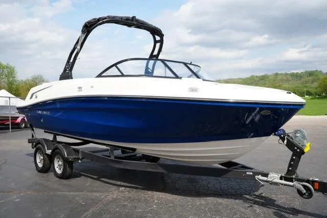 Slide: The Image of 2026 Bayliner VR6 Bowrider I/O boat on trailer, blue and white design, parked outdoors. - 4