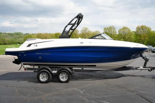 Slide: The Image of 2026 Bayliner VR6 Bowrider I/O boat on trailer, blue and white design, parked outdoors. - 5