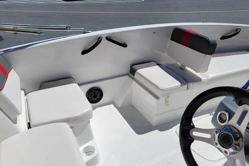 Slide: The Image of Interior of a 2021 Tahoe T16 boat featuring white seating and a steering wheel. - 10