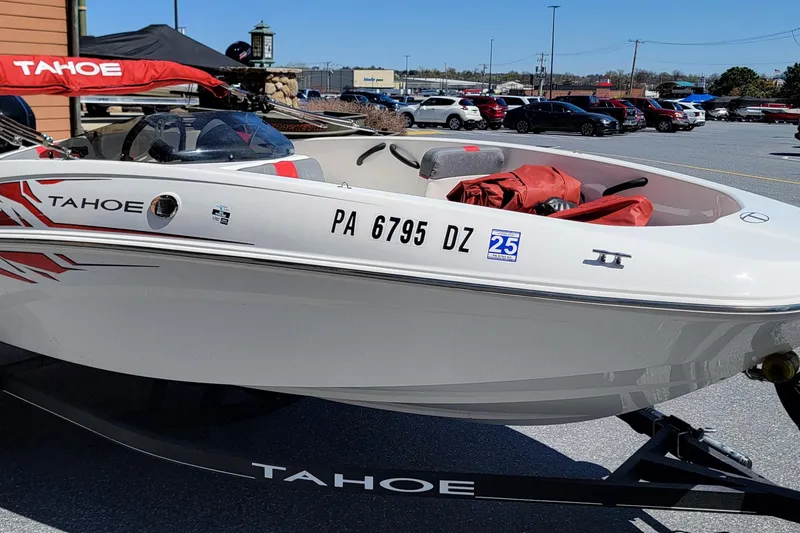 Slide: The Image of 2021 Tahoe T16 boat on trailer in parking lot, featuring sleek design and red accents. - 2