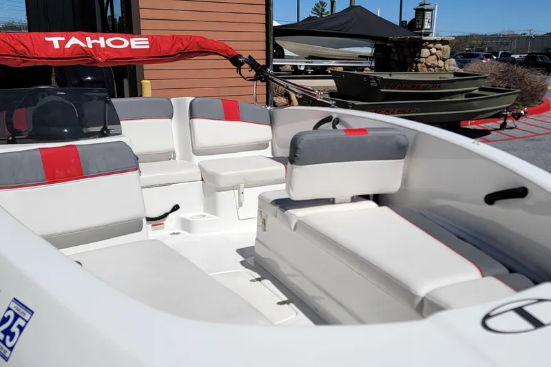 Slide: The Image of 2021 Tahoe T16 boat interior with red and gray seating, parked outdoors. - 7