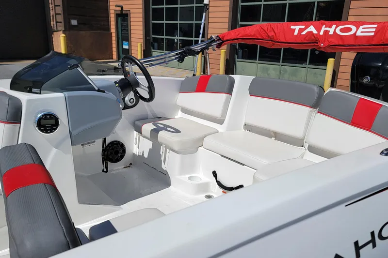 Slide: The Image of 2021 Tahoe T16 boat interior with red and gray seating, steering wheel, and dashboard. - 9