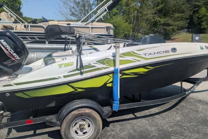 The Image of 2021 Tahoe T16 boat on trailer with green accents and Mercury engine. - 0