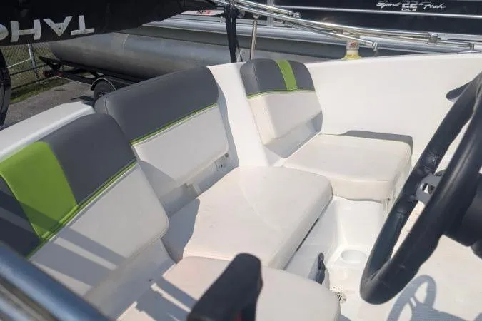Slide: The Image of 2021 Tahoe T16 boat interior with gray and green seating, steering wheel visible. - 11