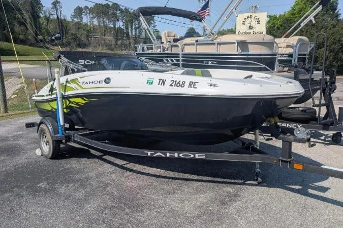 Slide: The Image of 2021 Tahoe T16 boat on trailer, parked outdoors at a dealership. - 13