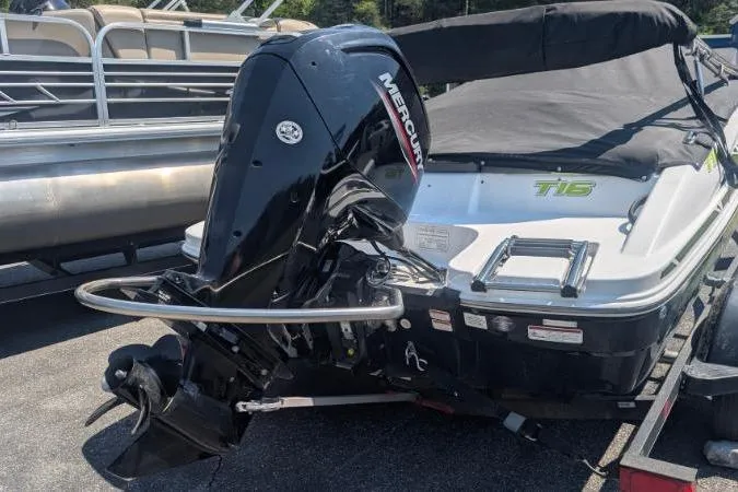 Slide: The Image of 2021 Tahoe T16 boat with Mercury outboard motor, covered and parked on a trailer. - 2