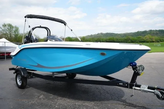 Slide: The Image of 2026 Bayliner M17 boat in vibrant blue on a trailer, parked outdoors. - 11