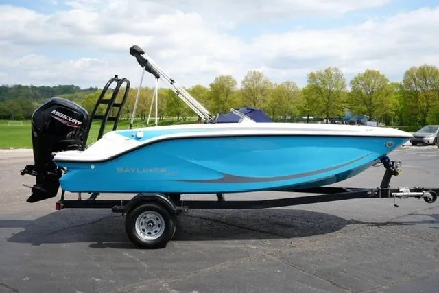Slide: The Image of 2026 Bayliner M17 boat on trailer, blue hull, parked outdoors. - 12