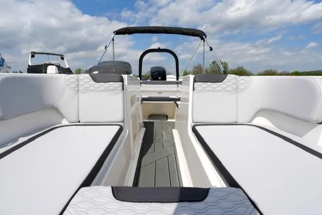 Slide: The Image of 2026 Bayliner M17 boat interior with white seating and open deck under blue sky. - 19