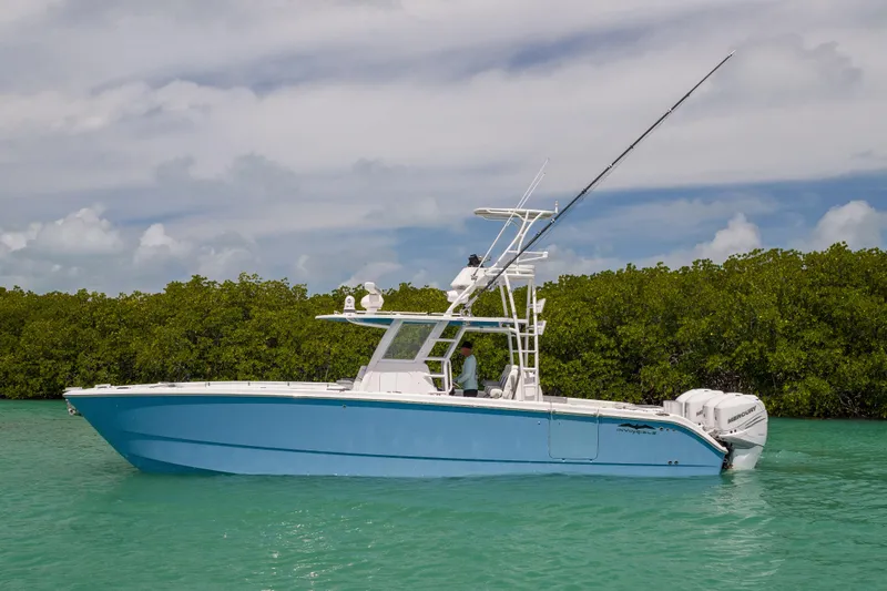 Slide: The Image of 2023 Invincible 37 Catamaran in turquoise waters, side view with lush greenery background. - 1