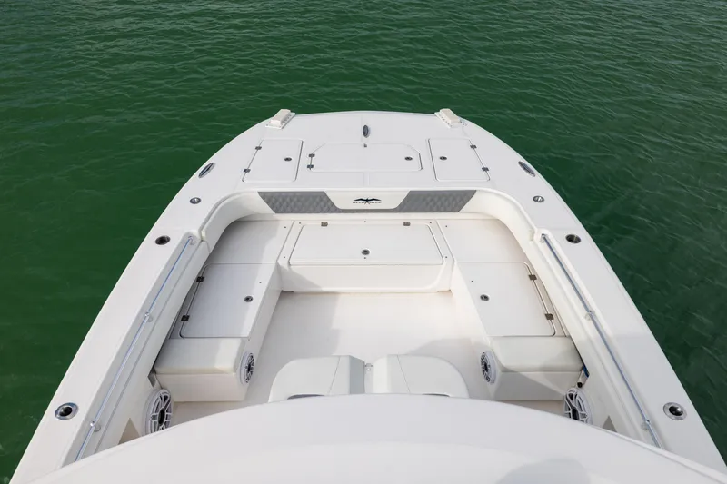 Slide: The Image of 2023 Invincible 37 Catamaran deck view, showcasing spacious seating and storage on calm water. - 12