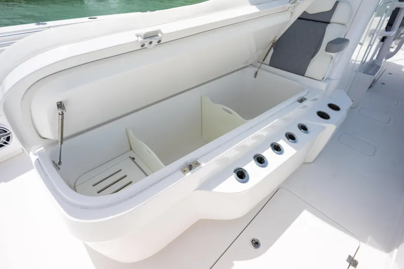 Slide: The Image of Open storage compartment on 2023 Invincible 37 Catamaran, featuring rod holders and seating. - 17