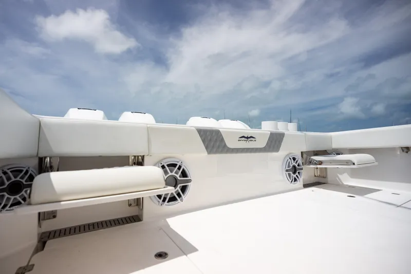 Slide: The Image of 2023 Invincible 37 Catamaran deck with speakers and seating under a cloudy sky. - 37
