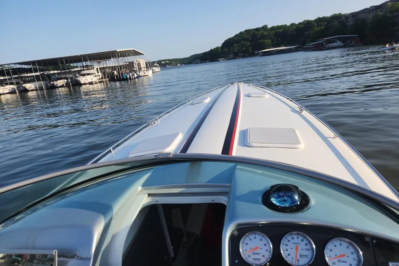 Slide: The Image of 2008 Formula 353 FASTech boat cruising on a serene lake near a marina. - 14