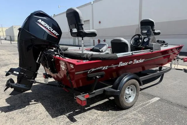 Slide: The Image of 2026 Tracker Bass Tracker Classic XL boat with Mercury engine, parked on a trailer. - 11