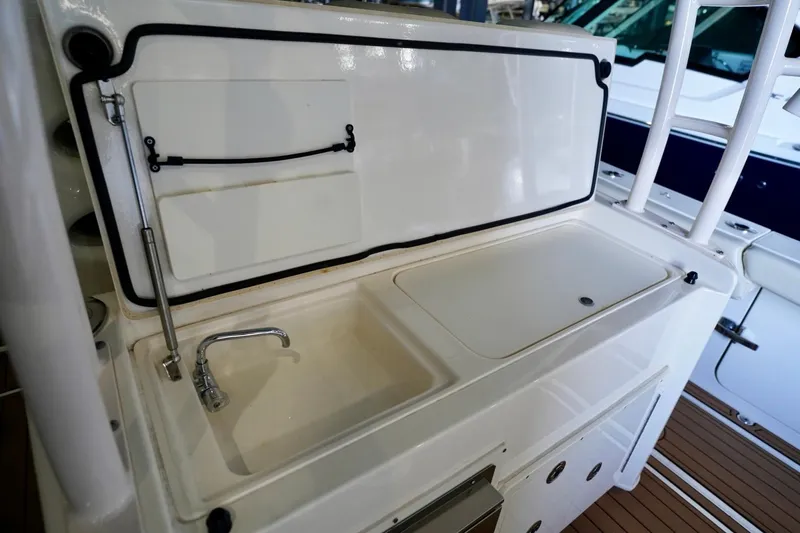 Slide: The Image of 2019 Cobia 344 Center Console boat sink and storage area. - 11