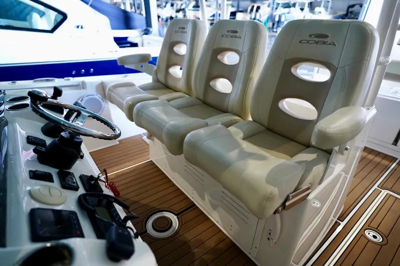 Slide: The Image of 2019 Cobia 344 Center Console boat interior with helm and cushioned seating. - 12