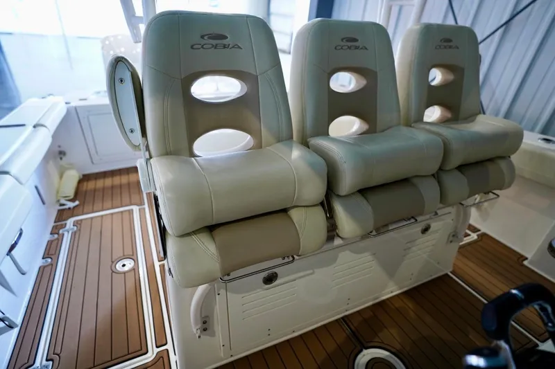 Slide: The Image of 2019 Cobia 344 Center Console boat seats with tan upholstery and wood-style flooring. - 13