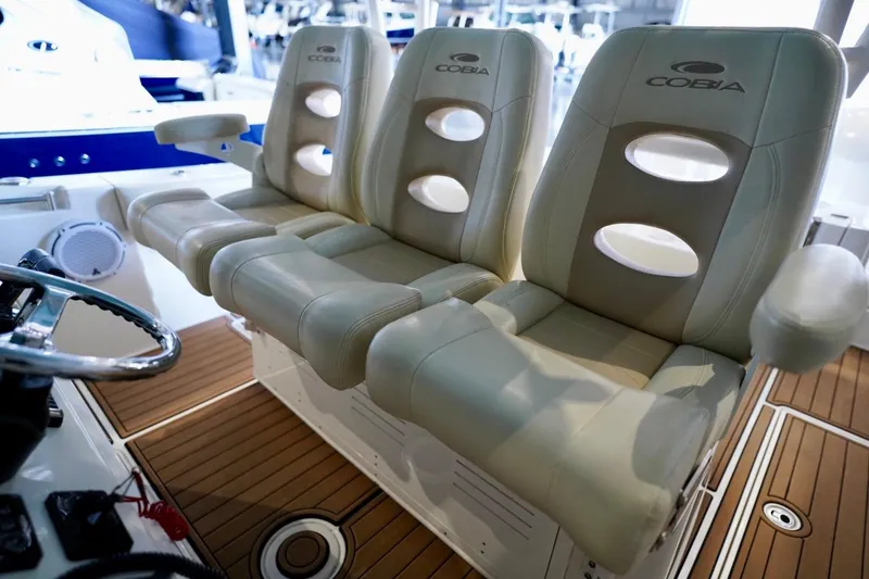 Slide: The Image of 2019 Cobia 344 Center Console boat seats with armrests and steering wheel. - 14
