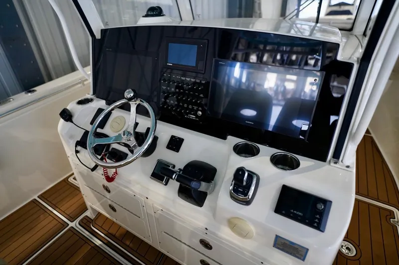 Slide: The Image of 2019 Cobia 344 Center Console boat dashboard with steering wheel and navigation controls. - 16