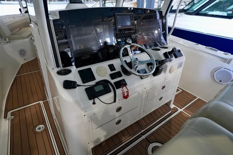 Slide: The Image of 2019 Cobia 344 Center Console boat interior with steering wheel and navigation equipment. - 18