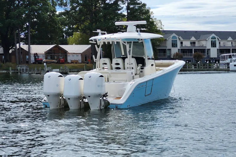 Slide: The Image of 2019 Cobia 344 Center Console boat on water near residential buildings. - 2