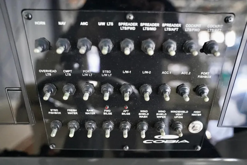 Slide: The Image of Control panel of a 2019 Cobia 344 Center Console boat with labeled switches. - 21
