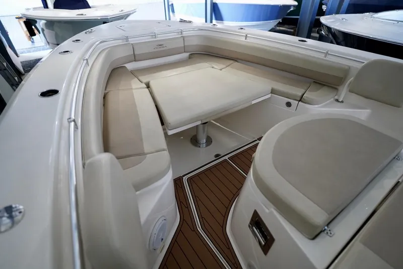 Slide: The Image of 2019 Cobia 344 Center Console boat interior with cushioned seating and wooden flooring. - 25