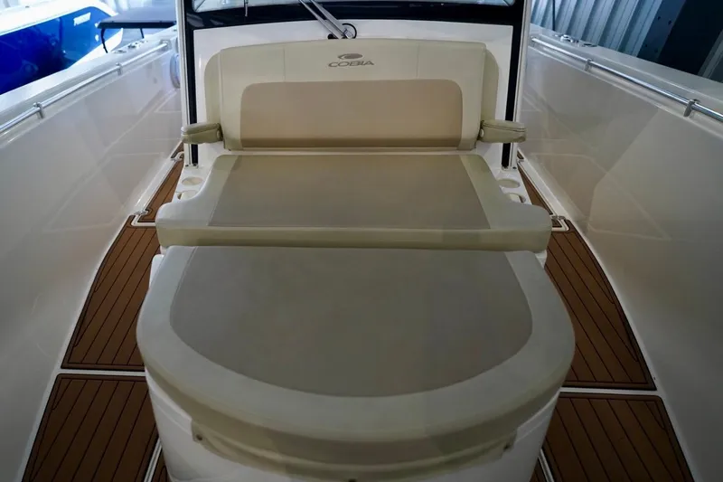 Slide: The Image of 2019 Cobia 344 Center Console boat interior with cushioned seating and wood flooring. - 27