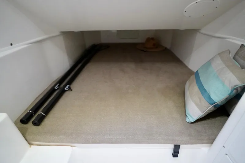 Slide: The Image of 2019 Cobia 344 Center Console cabin interior with cushions and fishing rods. - 30