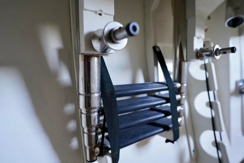 Slide: The Image of 2019 Cobia 344 Center Console boat ladder detail with metal and black straps. - 33