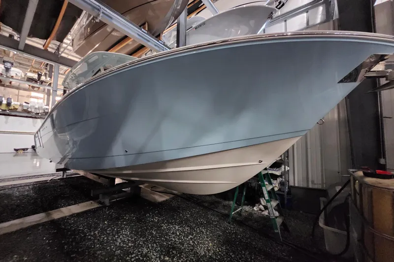 Slide: The Image of 2019 Cobia 344 Center Console boat in storage, showcasing sleek hull design. - 5