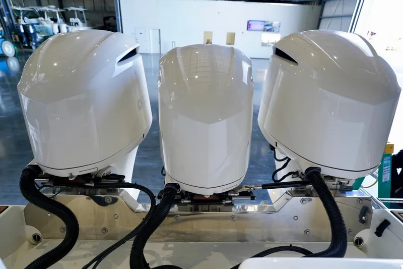 Slide: The Image of Triple outboard engines on a 2019 Cobia 344 Center Console boat in a showroom. - 6
