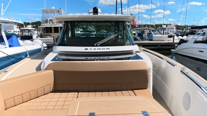 Slide: The Image of Saxdor 400 GTS 2027: Luxurious motorboat with beige upholstery, docked in a marina with other boats. - 38