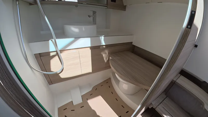Slide: The Image of The image shows a modern boat bathroom with wood paneling and a shower. - 32