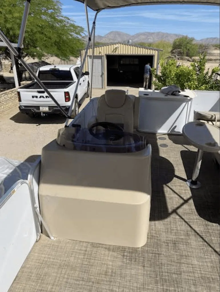Slide: The Image of 2019 SunCatcher 18F Pontoon parked outdoors, with Ram truck in background. - 6