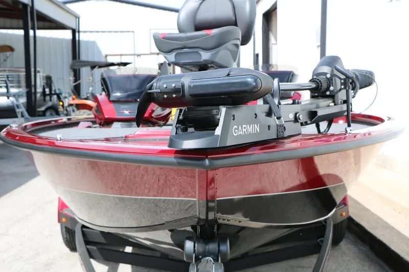 Slide: The Image of 2026 Vexus AVX 1985s boat with Garmin equipment, red exterior, parked outdoors. - 5