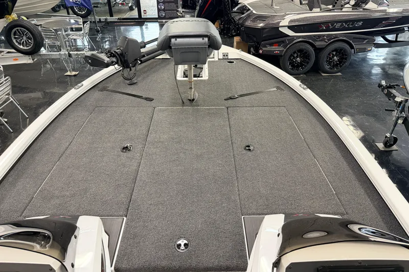 Slide: The Image of 2026 Vexus AVX 1985s boat interior with gray carpet and seating, displayed in showroom. - 18